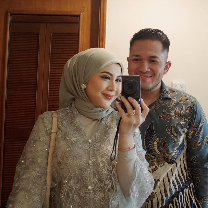 <p>Kesha juga mengunggah foto mirror selfie dengan suaminya Adhi. Kesha masih mengenakan kebaya dan hijab bernuanda sage sedangkan Adhi tampak gagah dengan kemeja batik bernuansa biru yang dipadukan celana panjang hitam. (Foto @kesharatuliu05)</p>