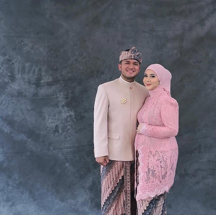 <p>Tak hanya mengenakan kebaya bernuansa sage, Kesha juga terlihat cantik menawan dengan balutan kebaya pink dengan hijab senada. Di sampingnya ada sang suami yang terlihat gagah dengan jas bernuanda coklat dan blangkon senda dengan bawahan kain batiknya. (Foto @kesharatuliu05)</p>