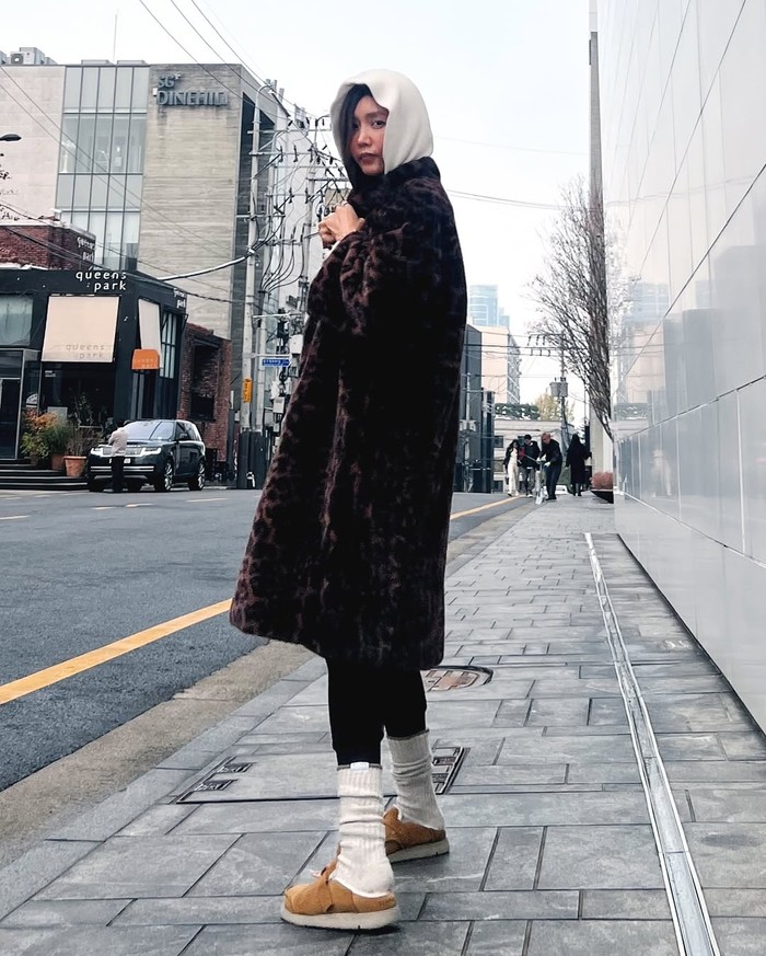 Chae Jeong An menciptakan outfit musim dingin yang trendi dengan mantel panjang bermotif macan tutul. Ia menambahkan item hoodie yang menonjol dengan menutupi kepalanya./ Foto: Instagram/chae_jungan