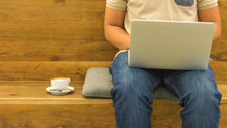 640286322 Using laptop and having coffee while working at home