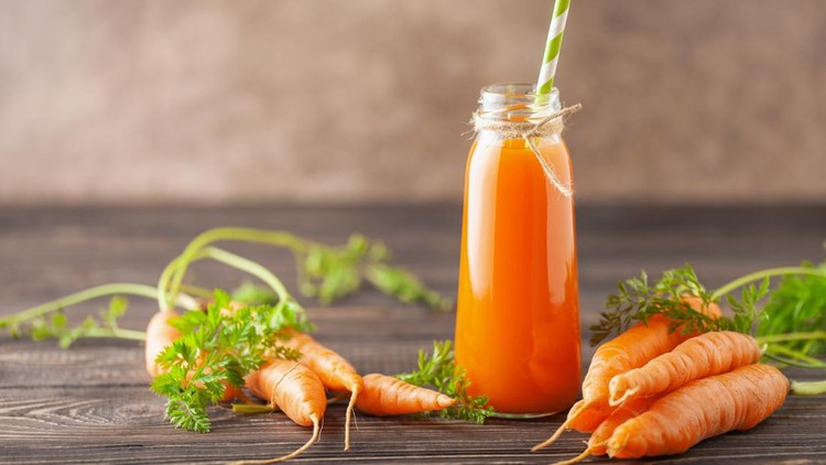 Fresh  carrot juice in glass bottle on a  wooden table