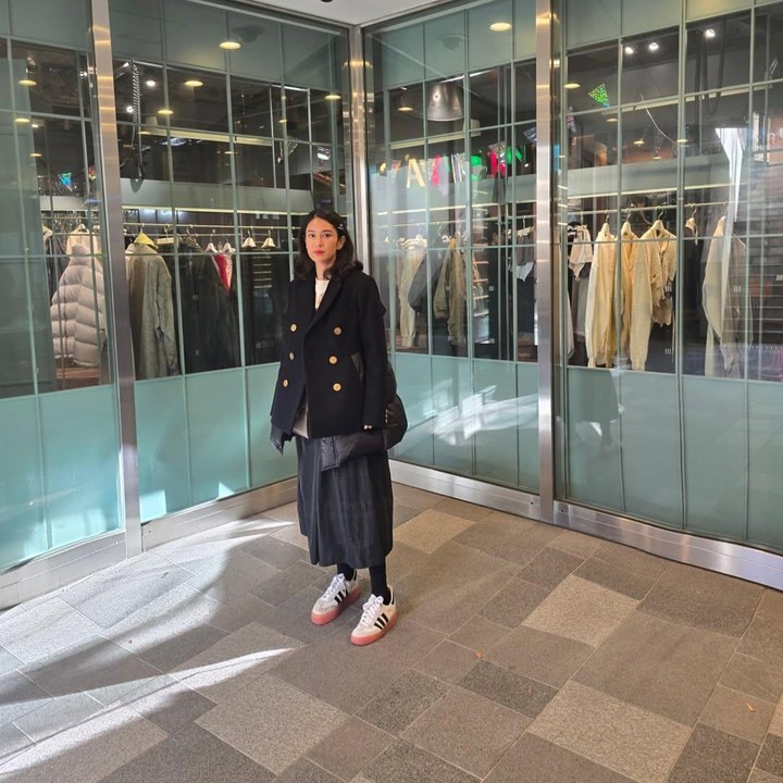 <p>Pada salah satu unggahan, terlihat Dian mengenakan coat tebal hitam dan rok warna senada. Ia pun memaduka tampilan ini dengan sepatu kets putih. (Foto: Instagram: @therealdisastr)</p>