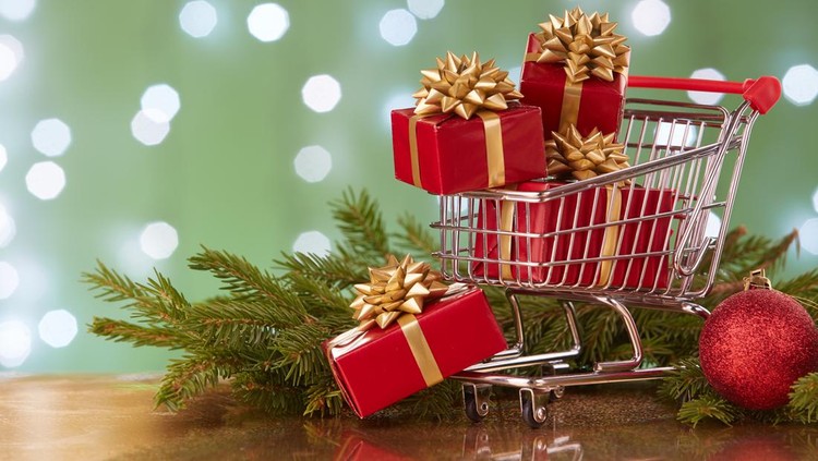 Shopping trolley with gift boxes and brenches of fir-tree with decoration on a green background with light of garland. Christmas and New Year sale.