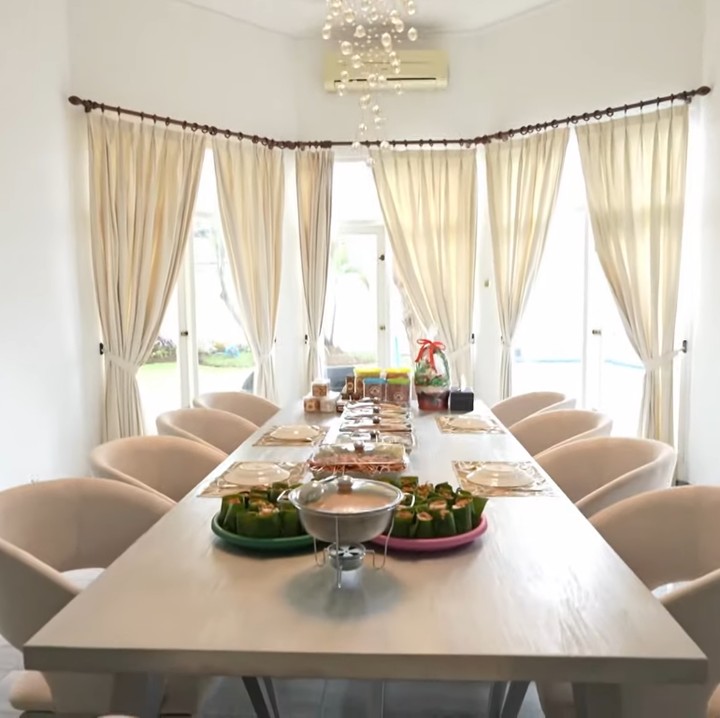 <p>Area meja makan pun sangat luas, Bunda. Di sini, Adly dan Angbeen memakai meja makan panjang lengkap dengan delapan kursi. Tidak ketinggalan, lampu gantungnya juga terlihat sangat estetik, lho. (Foto: YouTube TRANS7 OFFICIAL)</p>