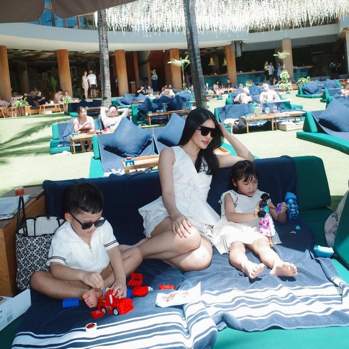 <p>Meski tengah berlibur, Anissa tak lupa membawa mainan kesukaan anaknya. Di sela menikmati <em>quality time</em> bersama, perempuan 30 tahun ini tetap membiarkan kedua anaknya main dengan mainan yang dibawanya. Alinea terlihat sibuk bermain boneka, semantara adiknya Aksara main mobil-mobilan. (Foto: Instagram @anissaaziza)</p>