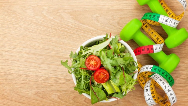 Dumbells, tape measure and healthy food over wooden background. Fitness and health. View from above