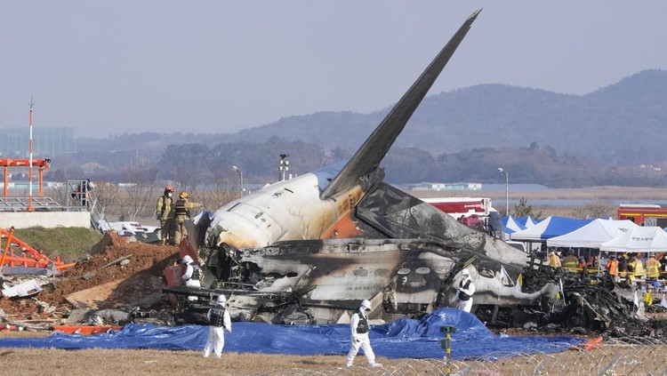 Potret Puing Jeju Air yang Kecelakaan, Hanya Sisa Ekor Pesawat Firefighters and rescue team members work near the wreckage of a passenger plane at Muan International Airport in Muan, South Korea, Sunday, Dec. 29, 2024. (AP Photo/Ahn Young-joon)