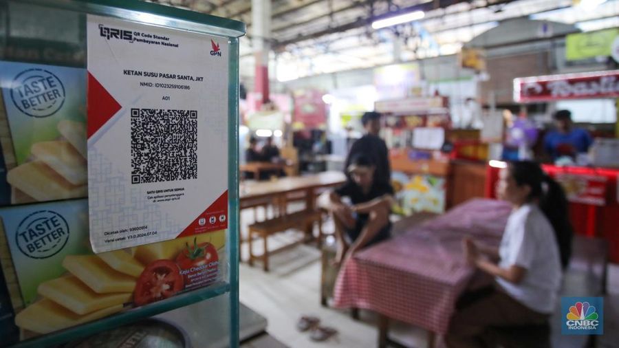 Pembeli memindai kode batang pembayaran Quick Response Code Indonesian Standard (QRIS) saat melakukan transaksi di Pasar Santa, Jakarta, Senin (30/12/2024). (CNBC Indonesia/Faisal Rahman)
