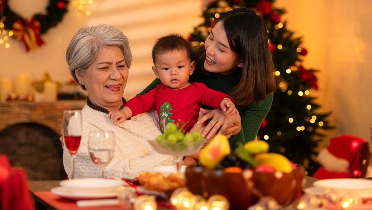 Grandmother, mother and little boy celebrate happily on Christmas night
