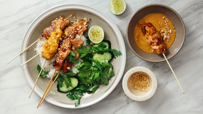 Thai chicken satay with peanut sauce on marble background