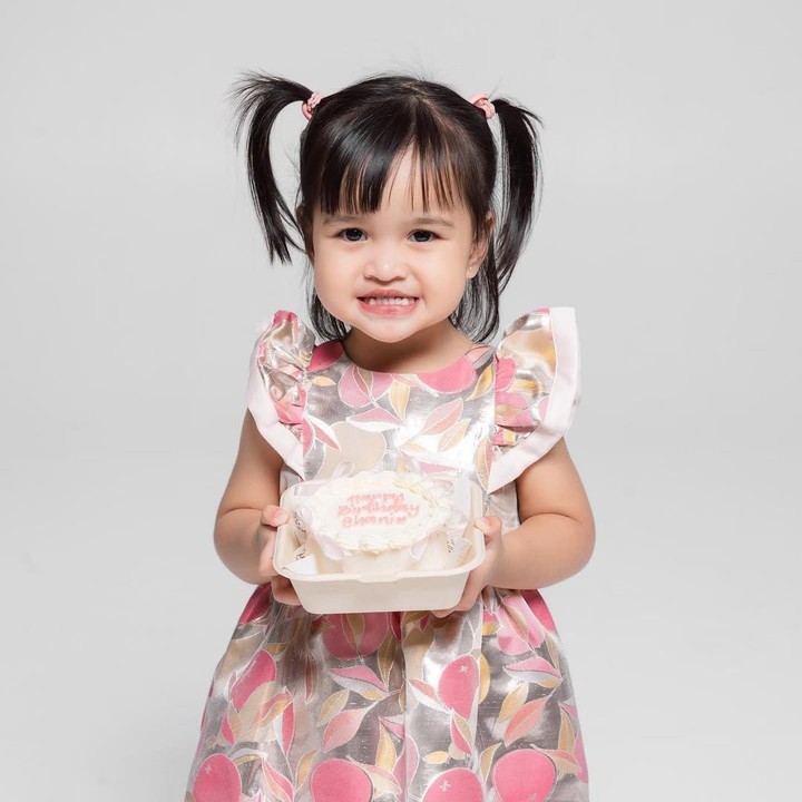 <p>Berbeda dengan sang kakak dan kedua orang tuanya, Shanin tampil dengan mengenakan dress warna-warni. Gayanya pun semakin menggemaskan dengan rambut yang dikuncir dua. (Foto: Instagram: @tasyakamila)</p>