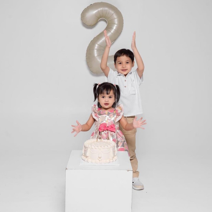 <p>Gadis cilik yang akrab disapa Shanin ini juga turut berpose bersama sang kakak. Keduanya terlihat menggemaskan berpose di depan kue ulang tahun. (Foto: Instagram: @tasyakamila)</p>