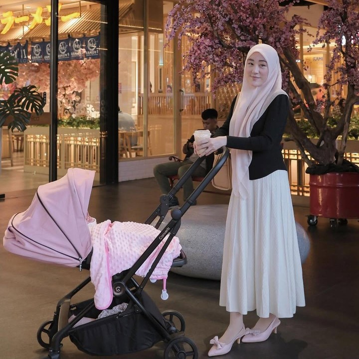 <p>Ketika tengah memomong Alesha, Larissa Chou selalu tampil modis. Dalam salah satu unggahan, Larissa memadukan <em>dress</em> putih dengan cardigan hitam. Warna kerudung dan sepatunya pun disamakan dengan warna <em>stroller</em> Alesha. (Foto: Instagram: @larissachou)</p>