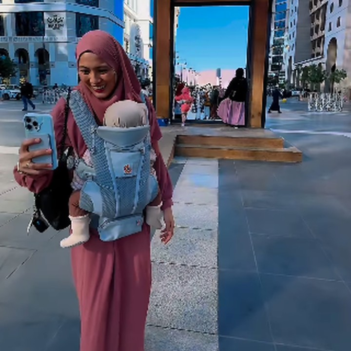 <p>Meski baru berusia delapan bulan, Lia sudah diajak untuk melihat Tanah Suci, Bunda. Lia pun terus berada dalam dekapan sang Bunda. (Foto: Instagram: @ichasoebandono/@dude2harlino)</p>