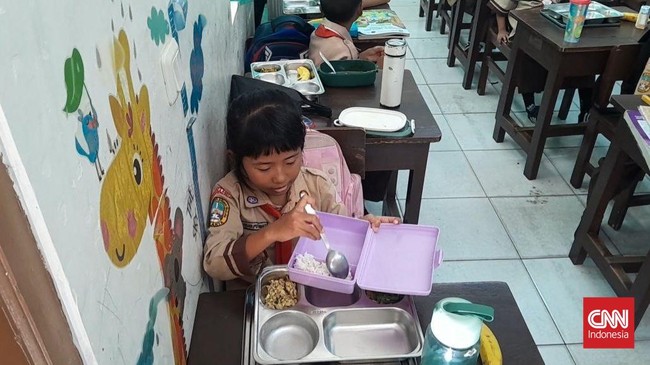 Seorang siswi kelas 2 di SDN Slipi 15 Annisa membungkus paket makanan yang diberikan dalam program makan bergizi gratis karena masih kenyang sarapan.