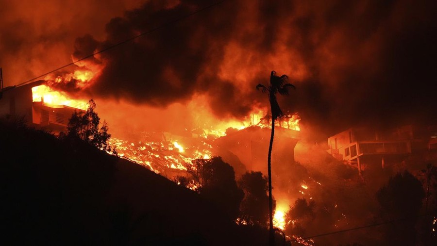 The Palisades Fire burns homes on a hilltop in the Pacific Palisades neighborhood of Los Angeles, Wednesday, Jan. 8, 2025. (AP Photo/Mark J. Terrill)