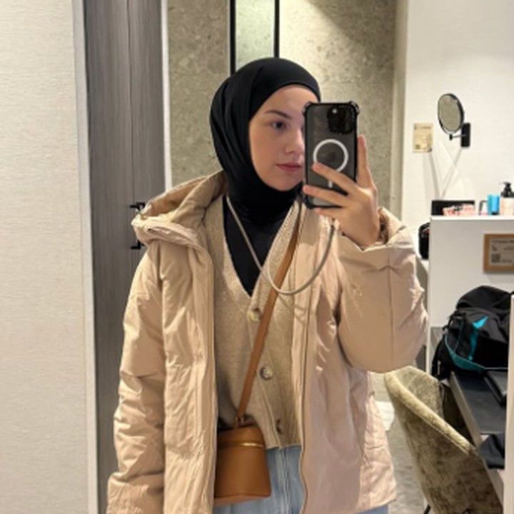 <p>Karena suhu yang sangat dingin, Irish Bella mengenakan pakaian berlapis mulai dari cardigan hingga mantel warna senada. Gayanya ini pun semakin lengkap dengan celana panjang dan <em>sling bag</em> cokelat. (Foto: Instagram: @_irishbella_)</p>