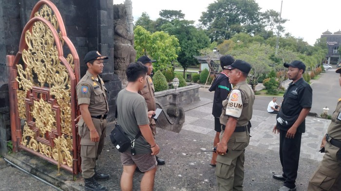 Petugas Satpol PP memaksa keluar beberapa remaja yang terindikasi bermain Koin Jagat di Bajra Sandhi, Selasa (14/1/2025). (Dok. Satpol PP Bali)