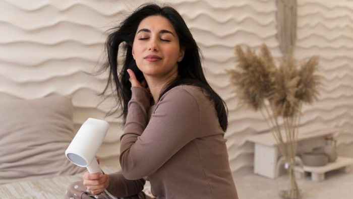 Ilustrasi mengeringkan rambut dengan hair dryer