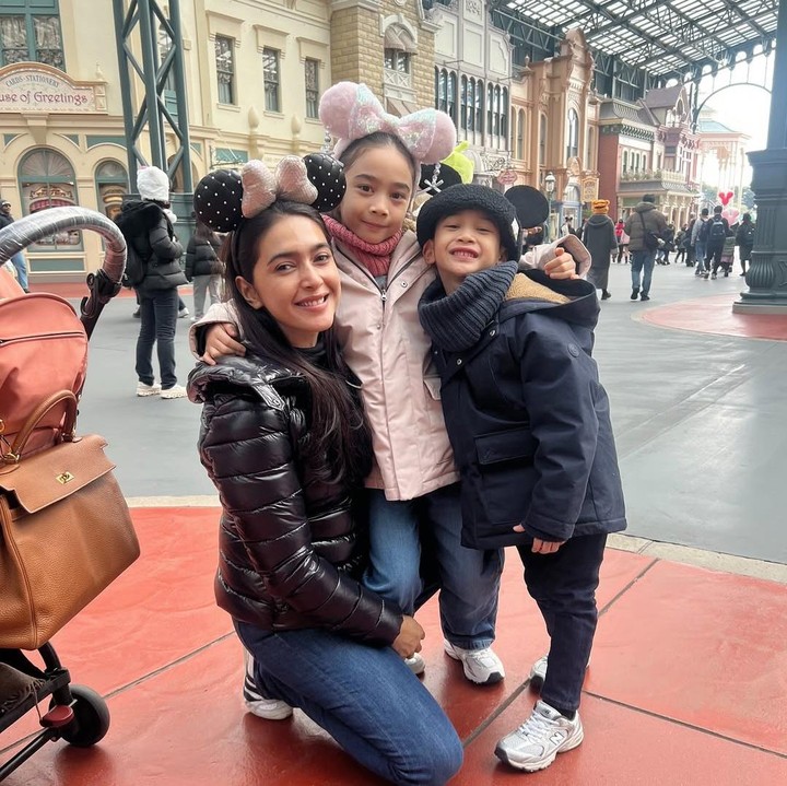 <p>Saat pergi ke Disneyland Tokyo, Raqeema memilih mantel merah muda dengan bando Minnie Mouse. Sedangkan sang adik tetap memakai mantel dan kupluk hitam. (Foto: Instagram: @nsyakieb)</p>