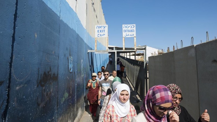 Bethlehem, West Bank, Palestinian Territories - July 24, 2013: Palestinians enter and exit the checkpoint and separation wall between Bethlehem and Jerusalem.