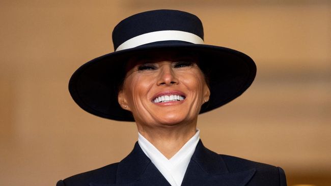 Melania Trump mencuri perhatian saat mengenakan topi dengan aksen lebar di pinggirannya. Topi ini disebut tak hanya anti badai, tapi juga anti ciuman.