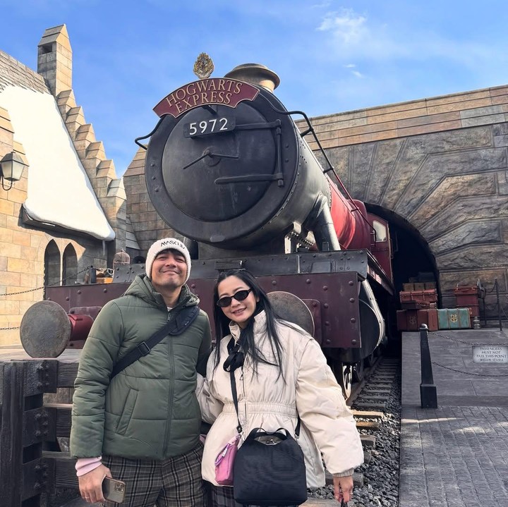 <p>Ketika mengunjungi Universal Studio Jepang, Hesti tampil cantik dengan mantel berwarna krem dipadu dengan kacamata hitam. Gayanya ini semakin lengkap dengan <em>slingbag</em> ukuran sedang warna senada. (Foto: Instagram: @hestipurwadinata)</p>