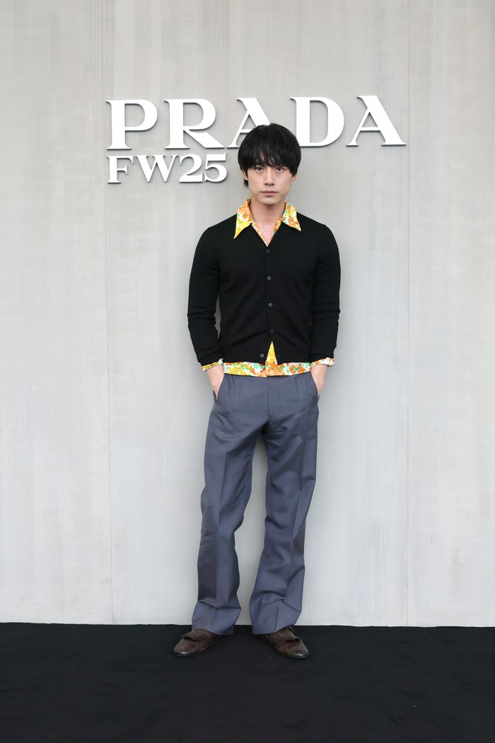 Nuansa serupa juga didapatkan dari Sakaguchi Kentaro, tapi dengan gaya androgini. Semburat ceria dari kemeja flora dikombinasi fashion items rona gelap, yakni cardigan hitam dan baggy pants abu-abu sampai loafers coklat/ Foto: Dok. Prada