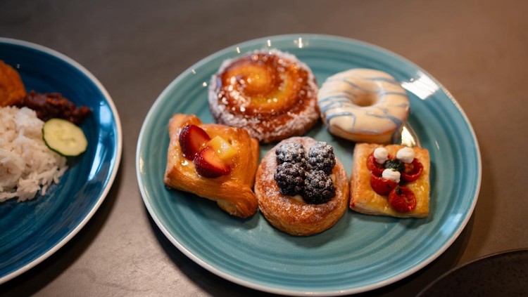 Various types of Danish pastries served on a plate on a wooden table. Breakfast concept.
