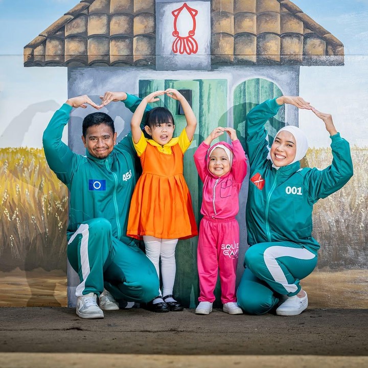 <p>"Jadi kemarin waktu mau bikin <em>reels</em> di sini sempat mikir siapa ya yang bisa bikin gambar ala-ala <em>Squid Game</em> di tembok belakang rumah kita. Terus, AHA! Guru les gambarnya Sada saja, karena memang gurunya Sada punya geng mural juga yang bisa mural TK, kamar, gedung-gedung, dll. Oke deh 'Kak enggak usah bagus-bagus ya, takut sayang kalau mau dipolosin lagi'. Eh taunya dibikin detail sampai padi-padiannya dilukis helai demi helai. Yasudah kita bikin kenang-kenangan dulu deh," papar Fitrop. (Foto: Instagram: @fitrop)</p>