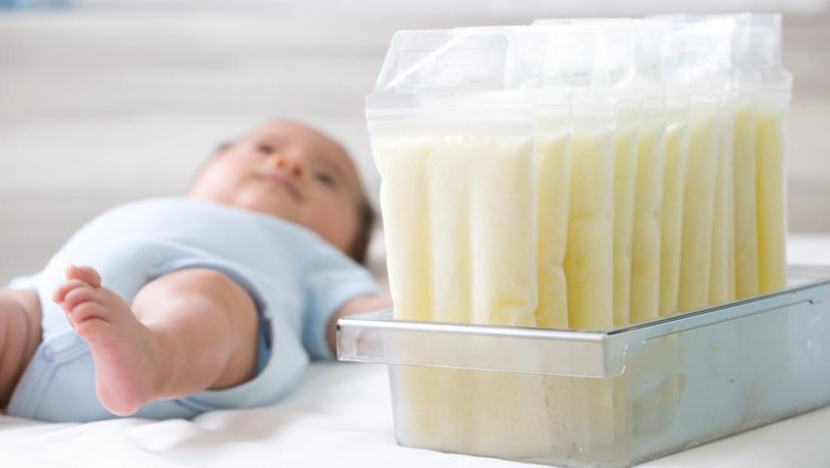 ASI perah Breast milk frozen in storage bag and baby lying on background