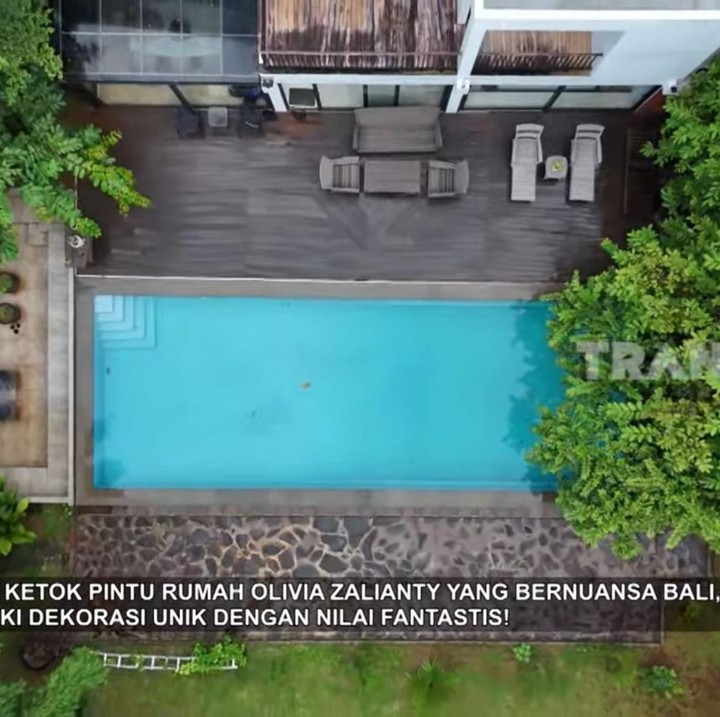 <p>Bahkan, ia juga menambahkan kolam renang dengan desain yang mirip seperti villa di Bali. Di area pinggir kolam renang, Olivia melengkapinya dengan beberapa sofa sebagai tempat bersantai. (Foto: YouTube TRANS7 OFFICIAL)</p>