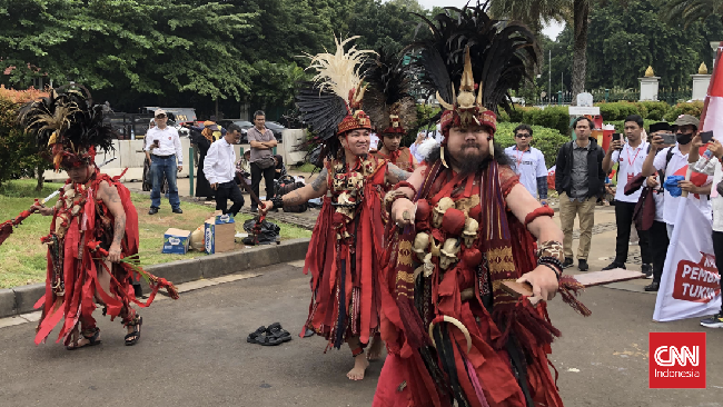 Para dosen ASN menampilkan tarian 'perang' Kabasaran asal Minahasa, Sulawesi Utara dalam aksi menuntut pembayaran tukin di kawasan Patung Kuda, Jakarta.