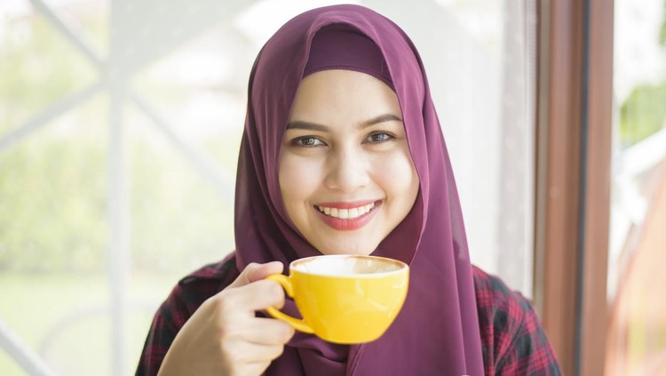 Muslim woman with hijab is working with laptop computer in coffee shop