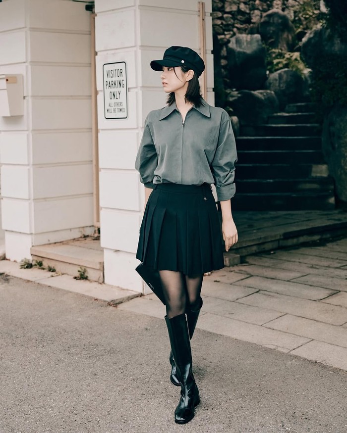 More fashionable! Ha Young menggunakan kemeja abu-abu dengan wide short skirt hitam, ia juga menggunakan stocking dan long boots hitam agar terlihat edgy, tak lupa menambahkan beret hat sebagai fashion statement./ Foto: Instagram.com/havv_y