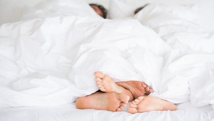 Young couple man and woman intimate relationship on bed feet