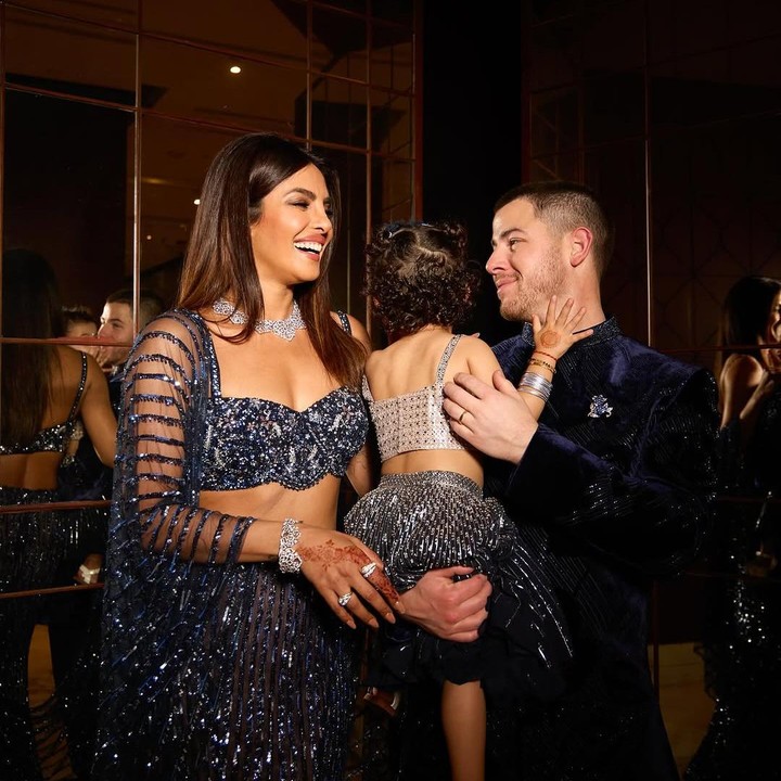 <p>Selama acara, Priyanka pun tampil cantik mengenakan sari modern warna navy. Sang suami dan putrinya pun turut mengenakan pakaian dengan warna serupa. (Foto: Instagram: @nickjonas)</p>