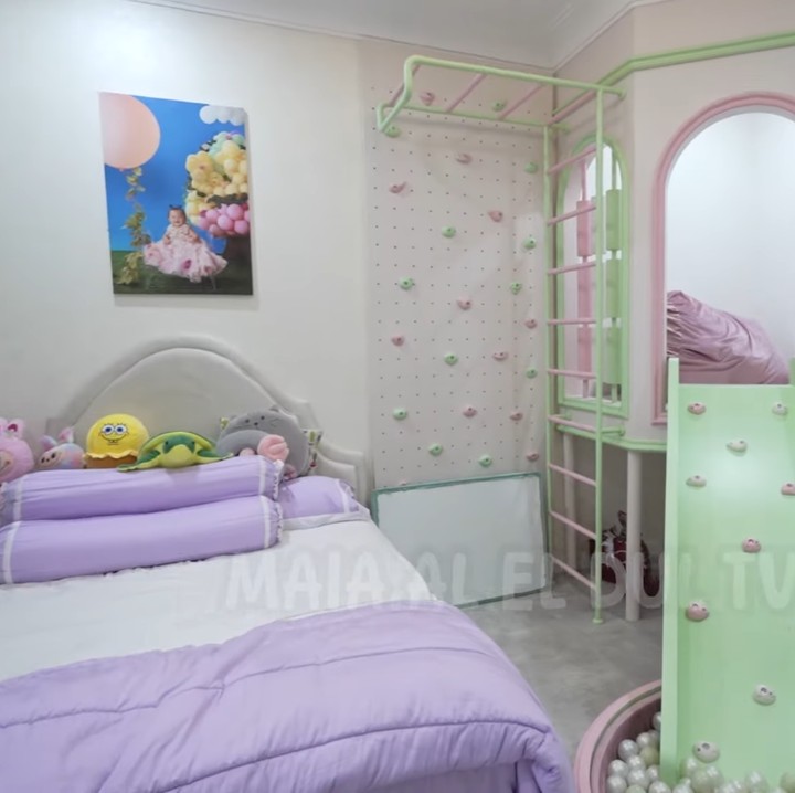 <p>Sementara itu, kamar kedua putrinya didominasi dengan warna putih, ungu, dan merah muda. Mereka memiliki area bermain pribadi seperti prosotan hingga <em>wall climbing</em>. Tidak hanya itu, kamar mandi keduanya pun saling terhubung, Bunda. (Foto: YouTube MAIA ALELDUL TV)</p>
