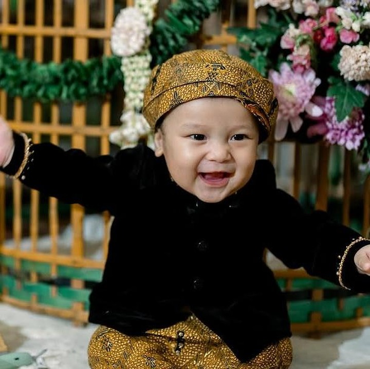 <p>Agham sendiri tampil menggemaskan dengan beskap warna hitam, Bunda. Gayanya semakin menarik perhatian dengan blankon cokelat yang kebesaran. (Foto: Instagram: @viavallen)</p>