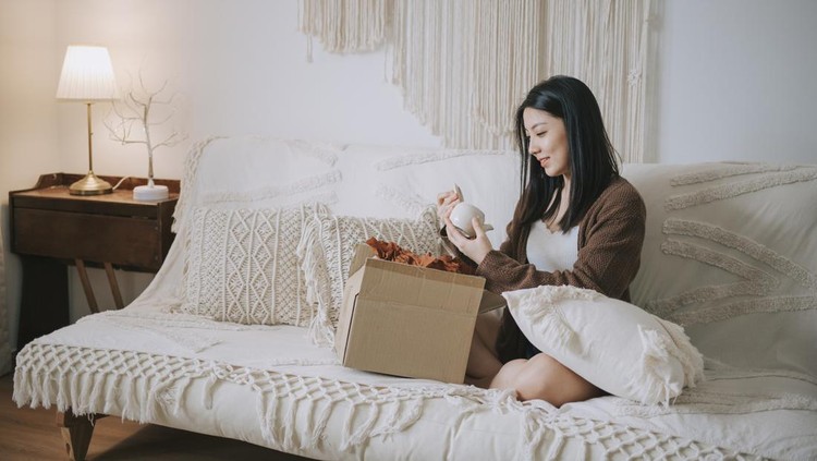 happy asian chinese woman received new teapot from online shopping at living room