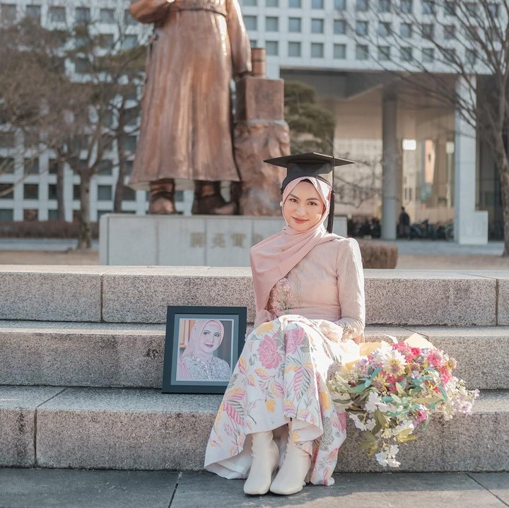 <p>Di unggahan lain, Xaviera membagikan foto kebersamaannya dengan mendiang sang Bunda yang berpulang pada 3 April 2023. Xaviera juga mem-posting fotonya di depan kampus saat mengenakan toga. Ia duduk di sebelah foto sang Bunda yang telah tiada. (Foto: Instagram @xavieraaputri)</p>