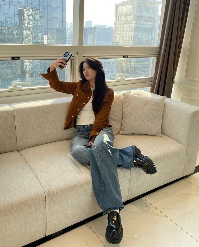 An Yujin memadukan kemeja suede coklat dengan kaus putih sebagai inner dan celana jeans untuk menciptakan tampilan yang trendi dan chic./ Foto: Instagram/_yujin_an