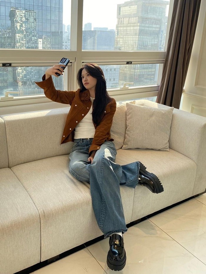 An Yujin memadukan kemeja suede coklat dengan kaus putih sebagai inner dan celana jeans untuk menciptakan tampilan yang trendi dan chic. / Foto: Instagram/_yujin_an