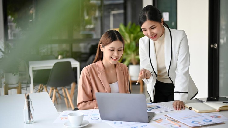 Ilustrasi pegawai di kantor Two beautiful young Asian businesswomen working together in the office. Professional Asian female boss training and coaching her assistant.