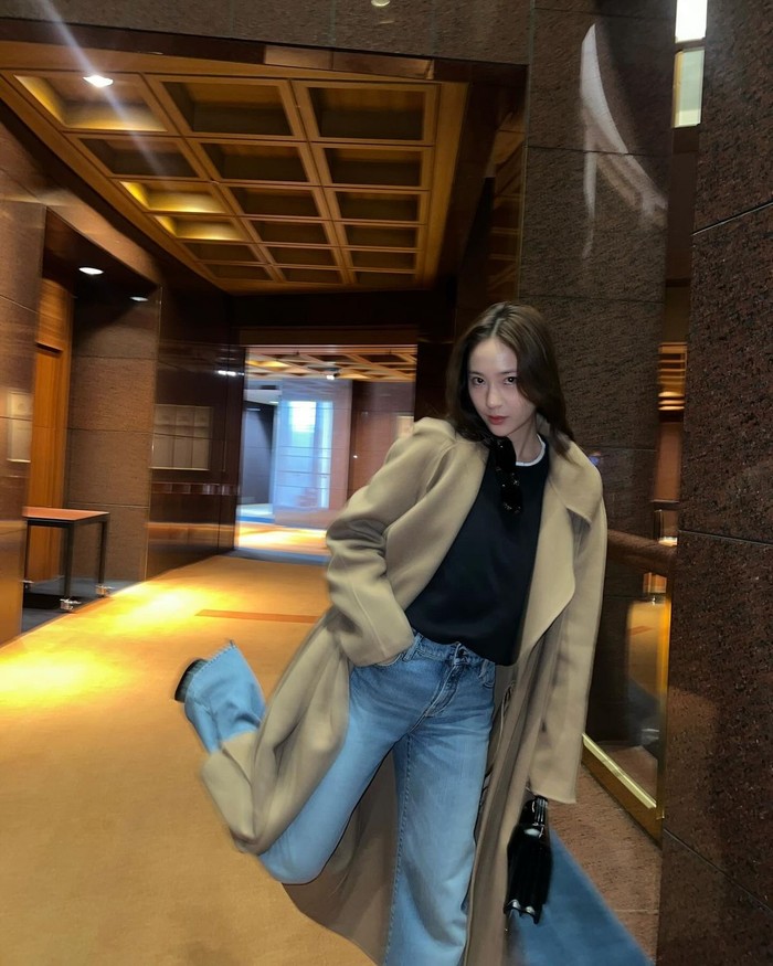 Krystal memadukan celana jeans berwarna terang dengan mantel cream panjang yang terlihat berkelas dan elegan tanpa aksesori yang mencolok./ Foto: Instagram/vousmevoyez