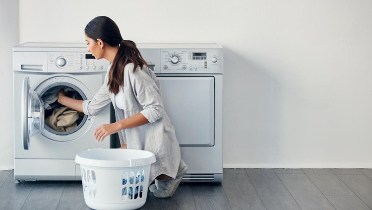 Shot of a young attractive woman doing her laundry at home