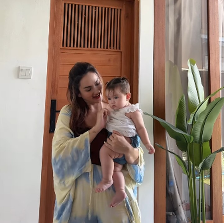 <p>Ketika membuat konten dengan sang Bunda, Baby Luv tampil cantik dengan baju putih dan celana <em>jeans</em>, nih. Gayanya semakin menarik perhatian dengan rambut yang dikuncir dua. (Foto: Instagram: @tengkudewiputri_tdp)</p>