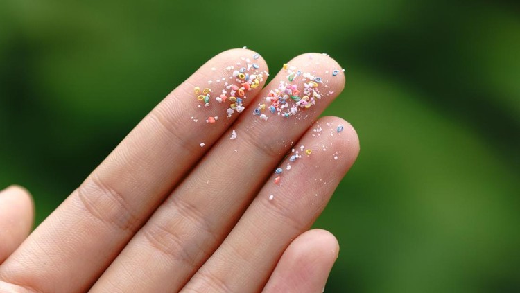 Close up side shot of microplastics lay on people hand.Concept of water pollution and global warming. Climate change idea.