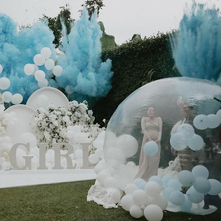 <p>Pesta gender reveal ini mengusung tema outdoor, di mana Aaliyah dan suaminya banyak menggunakan dekorasi warna putih. Pasangan ini meletakkan backdrop besar, bertuliskan <em>Boy or Girl,</em> yang dihiasi bunga dan balon putih. (Foto: Instagram @thariqhalilintar)</p>