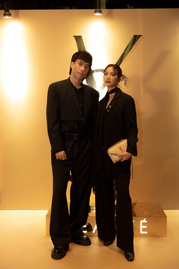 Couple stylish lainnya yang pakai outfit sarat identitas YSL adalah Vidi Aldiano dan Sheila Dara Aisha, Beauties. Sama-sama menampilkan all-black look, Vidi memakai setelan jas dengan jaket berdetail exposed stitches pada lapel. Platform loafers beri sentuhan kasual pada setelan jas tersebut. Sementara Sheila Dara turut mengimbangi dengan outfit chic, tersusun dari loose blazer detail lace dan cutout dipadu dengan wide-leg pants dan heels dalam warna senada. Aksesori bros emas serta clutch Saint Laurent menyempurnakan gaya/ Foto: Dok. YSL Beauty/VINCENTIUS